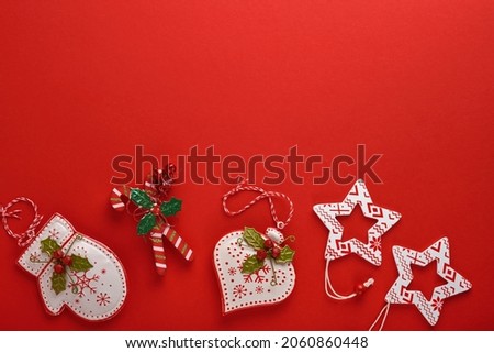 Christmas garland, toy and presents box. New Year or Christmas flat lay top view Xmas holiday celebration decoration red paper background with copyspace. Template mockup greeting card text design