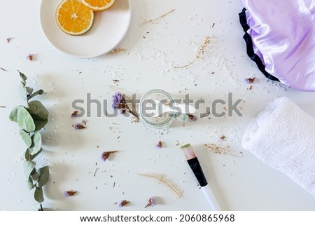 Health care spa concept. Mock up with shower cap, bath salts, towel, orange slices, brush and eucalyptus branches on white background. Flat lay, top view. Beauty, lifestyle, skin care, composition.
