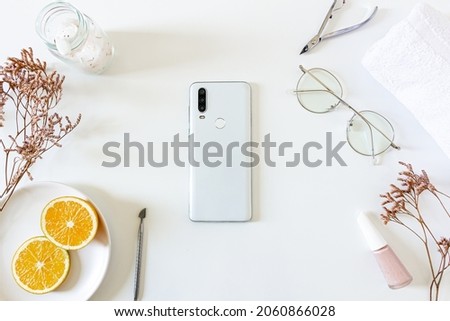 Health care spa concept. Mock up with dried flowers, glasses, mobile phone, orange slices, nails cutters, towel and bath salts on white background. Flat lay, top view. Beauty, skin care, composition.