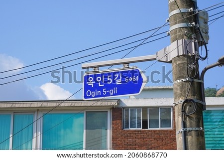 It is a sign showing the address of the road name in Korea. It says Ogin 5-gil in Korean.