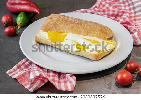 three cheese sandwich with tomato and cucumber on dark stone table
