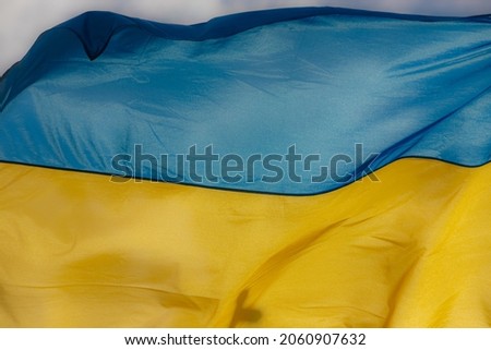 Ukraine flag waving on the wind against the blue sky.