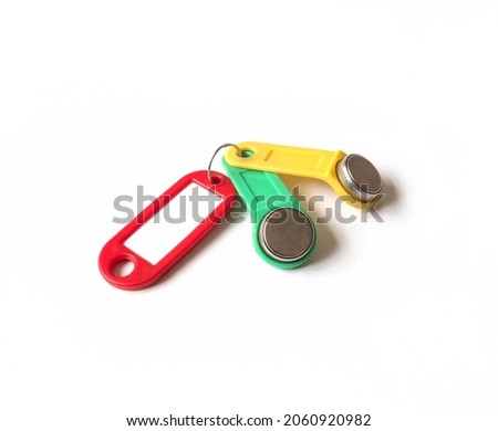 two touch memory keys yellow and green with a red tag lie on a white background. concept of security and access restrictions. copy space.