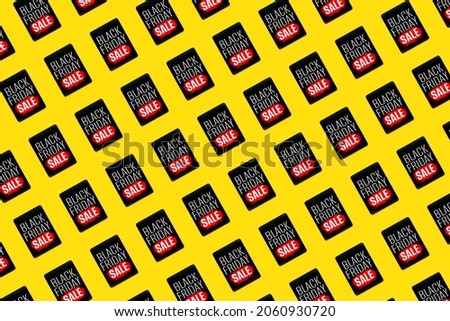 Pattern Black Friday Sale sign on digital tablet on bright yellow background. Modern shopping concept