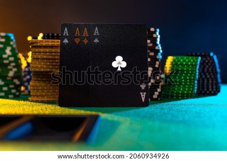 Black poker cards and chips on the green cloth of the poker table. Multicolored background. Casino. Online casino. Gambling business. there are no people in the photo.