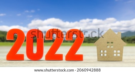 House model and number 2022 with landscape back background for finance and banking concept