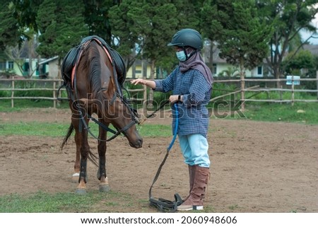 Asian girl stroking her favorite horse. bonding between horse and rider