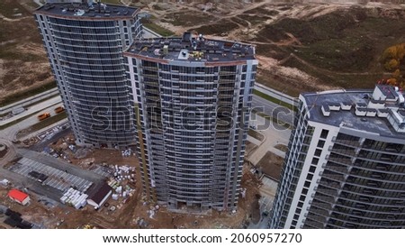 Construction of modern multi-storey buildings. Construction of a new city block. Buildings under construction site. Aerial photography in cloudy weather.