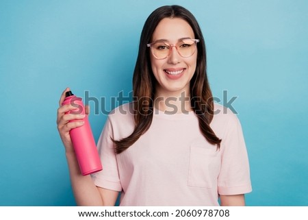 Photo of cheerful pretty lady hold bottle hair spray wear t-shirt haircare isolated turquoise color background