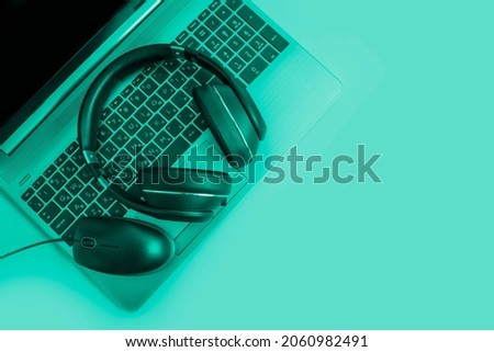 laptop, headphones on a colored background

