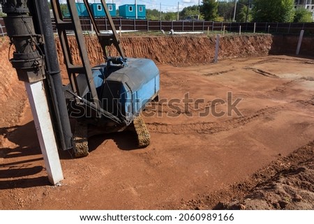 Foundation piles drilling machine. Driving piles for the foundation of a new house. Hydraulic pile drilling machine at industrial construction site. Royalty-Free Stock Photo #2060989166