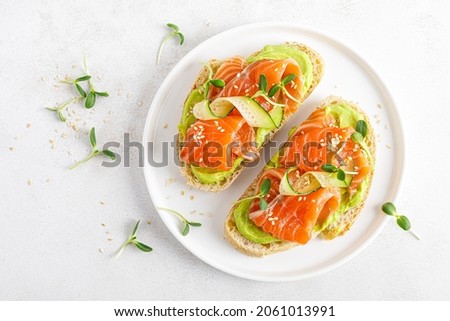 Open sandwiches with salted salmon, guacamole avocado and microgreens. Seafood. Healthy food. Top view. Royalty-Free Stock Photo #2061013991