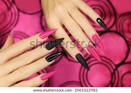 Fashionable pink and black manicure on long sharp nails. Royalty-Free Stock Photo #2061022982