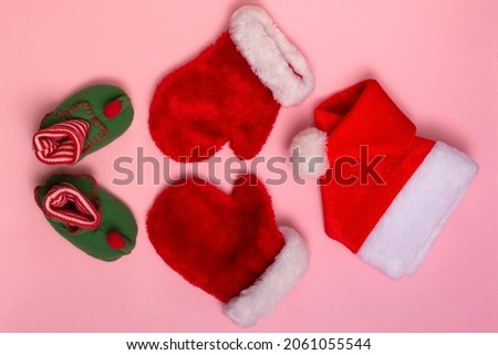 Santa Claus hats, mittens and socks mockup on pink background. Christmas flat mockup, close up top view