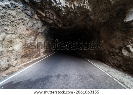 Car tunnel in the rock. The road to Cape Teno. Tenerife. Canary Islands. Spain.