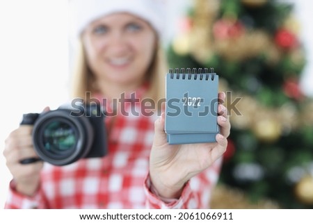 Young woman photographer holding calendar for 2022 closeup