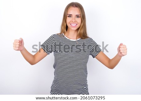 Happy beautiful blonde girl wearing striped t-shirt on white background Holding Empty Paper Board Advertising Offer Text Standing. Autumn Advertisement Banner.