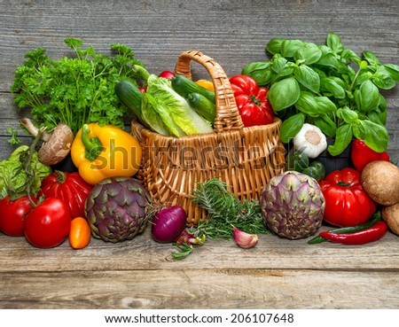 vegetables and herbs on wooden background. fresh raw food ingredients. country style picture. selective focus