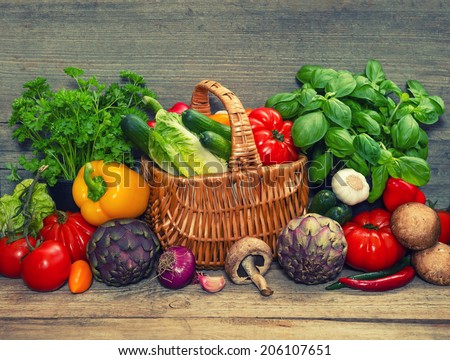 fresh vegetables and herbs on wooden background. raw food ingredients. retro style toned picture