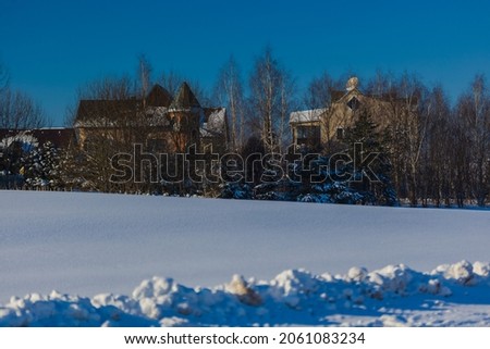 Winter landscape. White snowy field and trees covered in snow in sunlight against a blue sky background. Background for design.