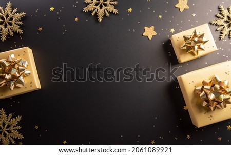 Top view of Black Friday Christmas gift box and golden snowflake on dark background. Shopping concept boxing day and Black Friday composition.