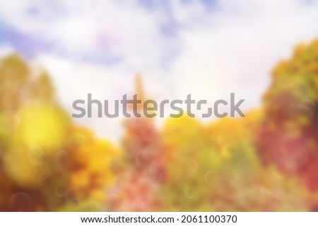 Blurred colorful autumn background. Defocused natural yellow tree background with sun beams.
