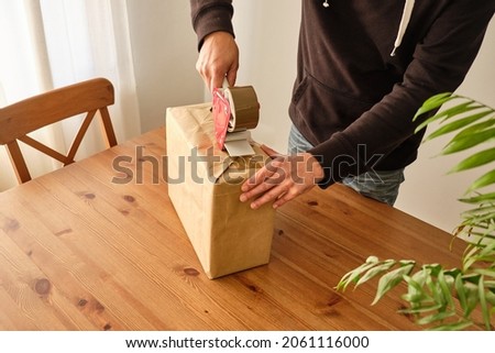 A person packing a package to make a shipment Royalty-Free Stock Photo #2061116000