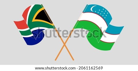 Crossed and waving flags of South Africa and Uzbekistan