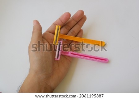 used pink and yellow beard razor on white isolated background photo