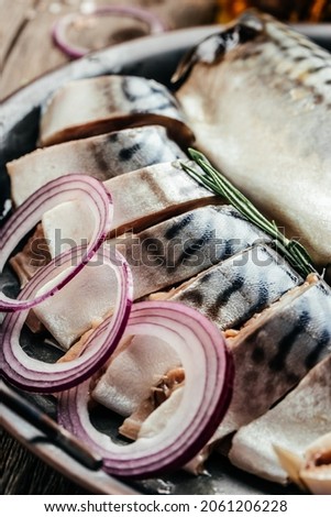 sliced marinated mackerel or herring with onion and spices. Healthy food, diet or cooking concept. vertical image. top view,