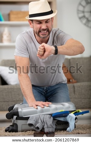 man preparing for vacation travel being late Royalty-Free Stock Photo #2061207869