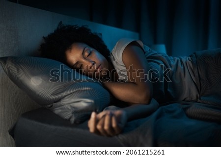 Beautiful african american woman sleeping in her bed at night Royalty-Free Stock Photo #2061215261