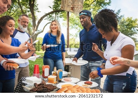 Friends drinking and eating at a tailgate party Royalty-Free Stock Photo #2061232172