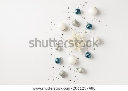 Top view photo of blue white and silver christmas tree decorations snowflake balls and sequins on isolated white background with copyspace