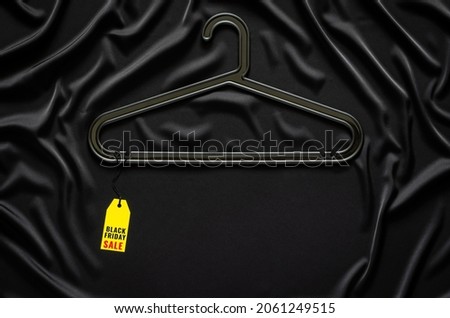 A black hanger with yellow price tag with word on black cloth. Black Friday concept.