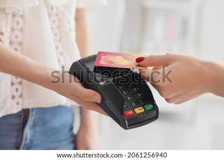Woman paying for purchase via terminal, closeup