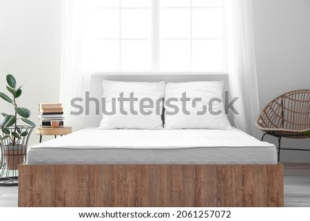 Soft orthopedic mattress on bed in room Royalty-Free Stock Photo #2061257072