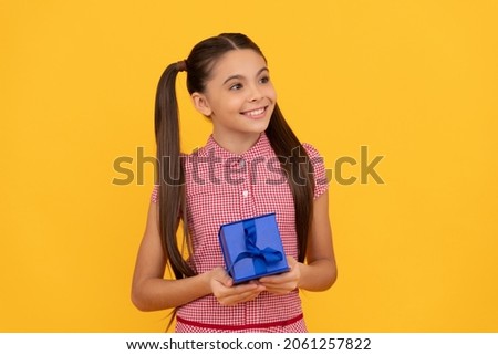 happy kid hold present box on yellow background, childrens day