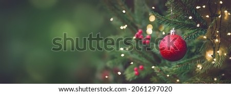 Christmas and New years eve Background. Beautiful Wide Angle Holiday Template with Christmas red ball on fir tree and highlights. Panoramic classic header Web banner with copy space for design. Royalty-Free Stock Photo #2061297020