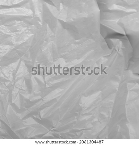 Reflected light and shadow on creases and folds in white plastic sheeting. monochrome light and texture, abstract background image.