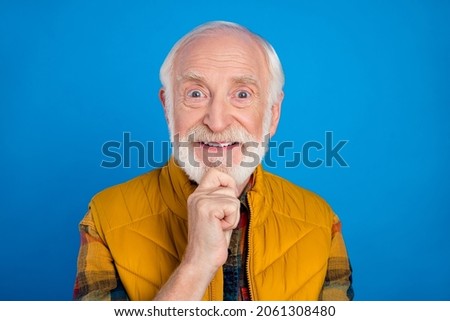 Portrait of attractive cheerful funny grey-haired man creating solution touching chin isolated over vivid blue color background
