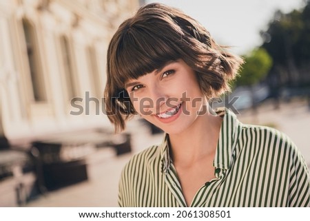 Photo portrait female student in striped shirt smiling overjoyed having nice mood in sunny weather