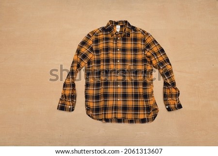 checkered paid shirt closeup isolated on wooden background

