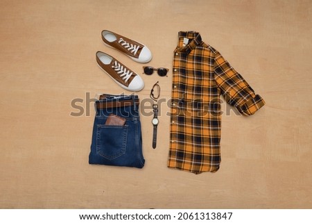 Top view of Men's clothes and accessories on wooden background flat lay