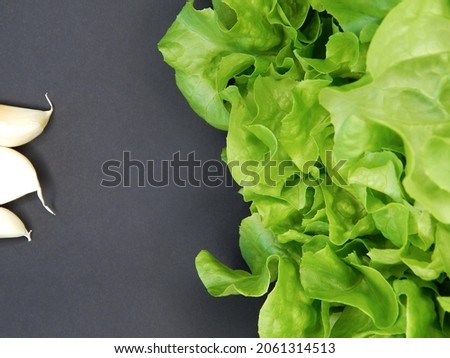 Background from various fresh vegetables and fruits. Lettuce, carrots, bell peppers, zucchini, tomato, garlic, apple, pear, banana on a black background. 