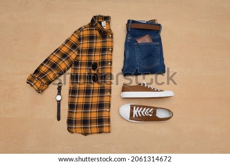Top view of Men's clothes and accessories on wooden background flat lay
