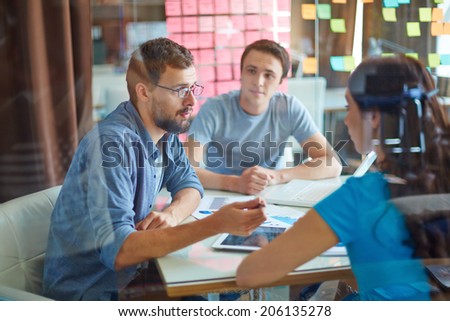 Young man consulting his business partner at meeting in office Royalty-Free Stock Photo #206135278