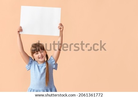 Little girl with blank paper sheet on color background