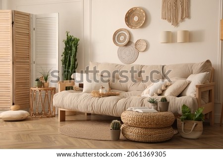 Stylish living room interior with comfortable wooden sofa and beautiful houseplants Royalty-Free Stock Photo #2061369305