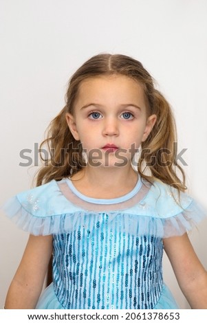 Adorable little girl in blue princess dress looking at camera on white background in studio 3 three years old photo for passport or ID card